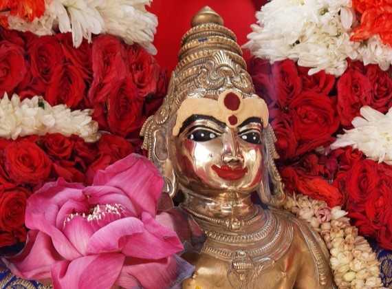 Close-up of Lord Murugan statue adorned with vibrant flowers during Vaigasi Visagam at HTSBT.