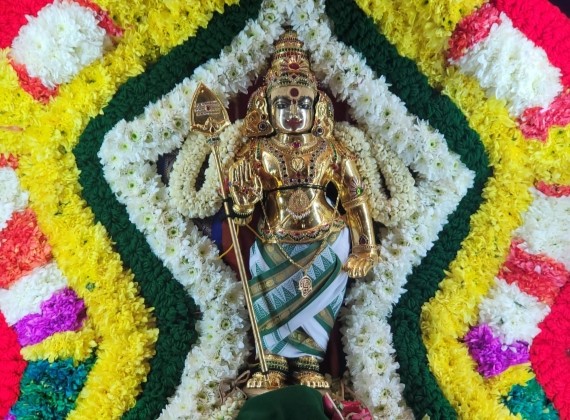 Lord Murugan decorated with colorful floral arrangements during Kantha Sashti prayers at the temple.